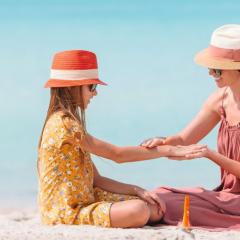 Lady applying sunscreen to child